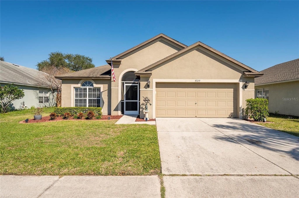 single story home with a front yard, concrete driveway, an attached garage, and stucco siding