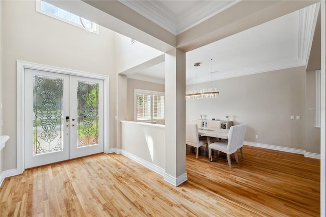 doorway featuring french doors, ornamental molding, wood finished floors, and baseboards