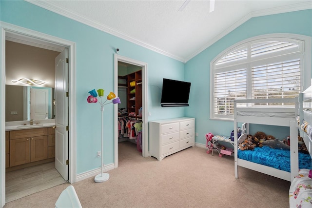 bedroom with light colored carpet, lofted ceiling, a spacious closet, crown molding, and a sink