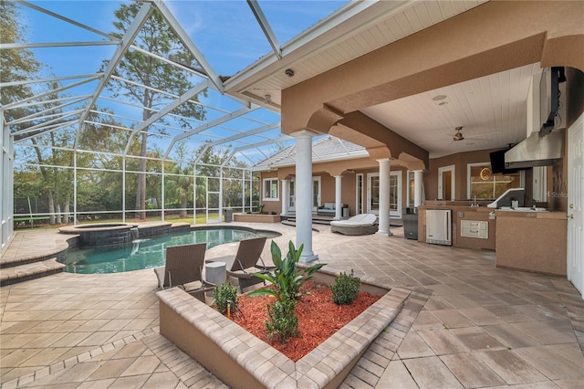 view of pool featuring a patio, exterior kitchen, and glass enclosure