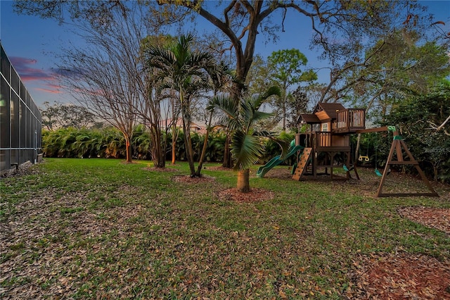 view of yard with a lanai and a playground