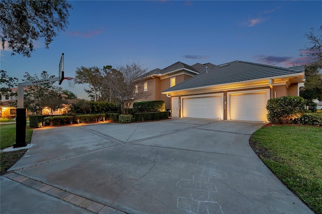 view of front of house featuring a garage, driveway, and stucco siding