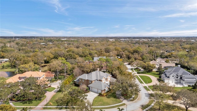 drone / aerial view featuring a residential view and a view of trees