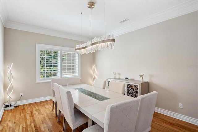 dining room featuring ornamental molding, wood finished floors, and baseboards