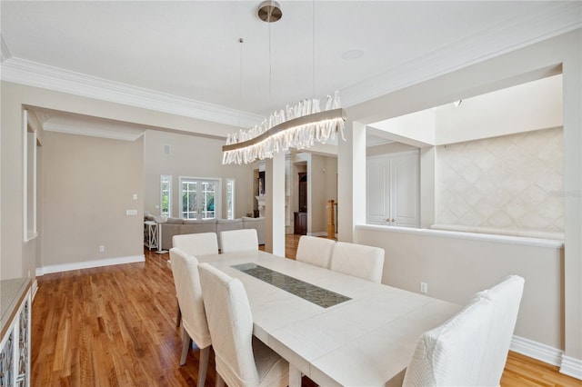 dining area featuring ornamental molding, wood finished floors, and baseboards