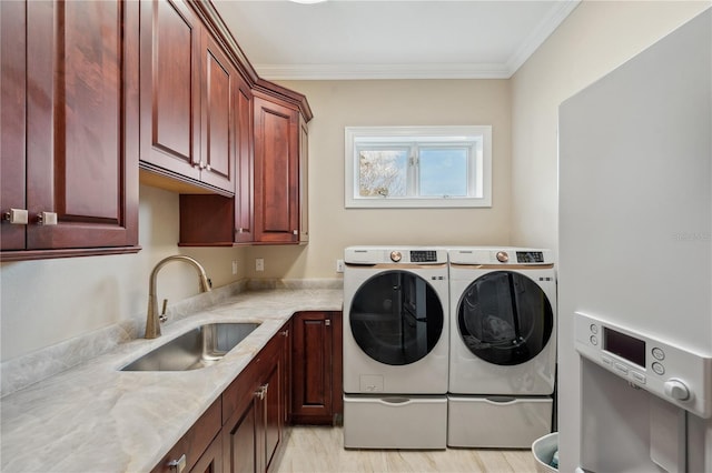 clothes washing area featuring independent washer and dryer, a sink, cabinet space, and crown molding