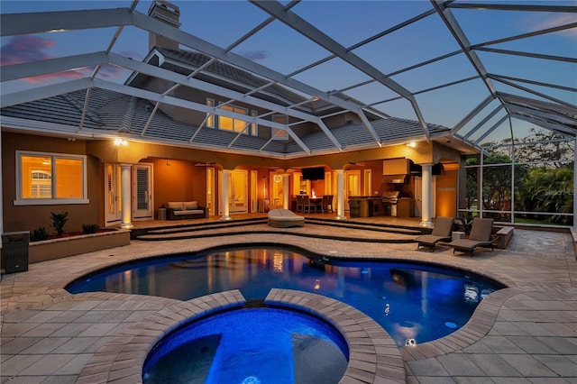 view of pool with a patio area, a lanai, and a pool with connected hot tub