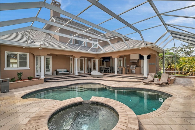 view of swimming pool featuring a pool with connected hot tub, a patio, and a lanai