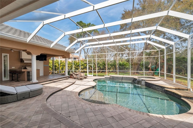 view of swimming pool with a lanai, a pool with connected hot tub, a patio, and area for grilling