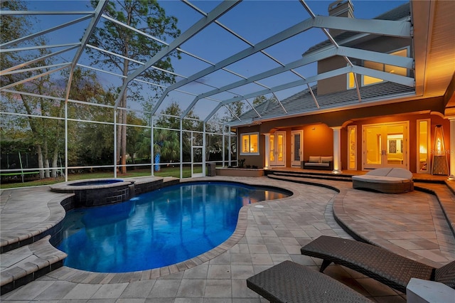 view of pool featuring a lanai, a pool with connected hot tub, french doors, and a patio