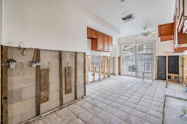 interior space with a wainscoted wall, visible vents, and ceiling fan