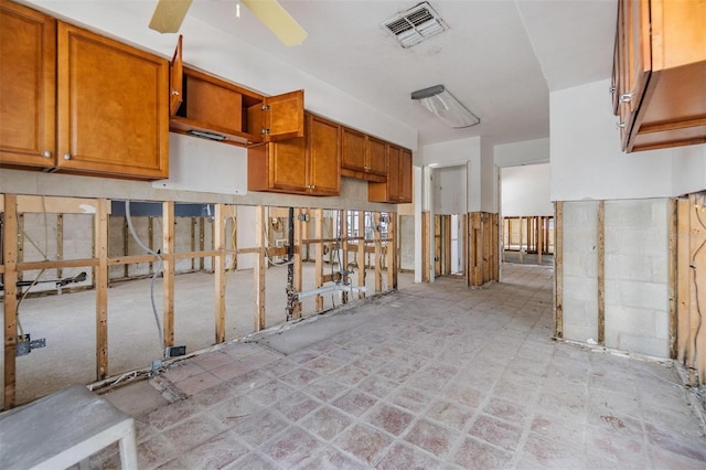 kitchen featuring visible vents, brown cabinetry, and a ceiling fan