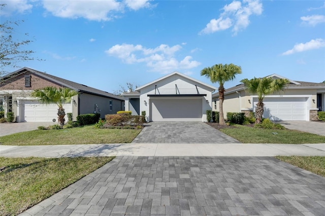 ranch-style home featuring a front yard, decorative driveway, an attached garage, and stucco siding