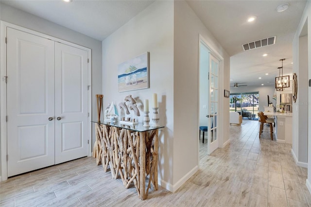 hallway with recessed lighting, visible vents, light wood-style flooring, and baseboards