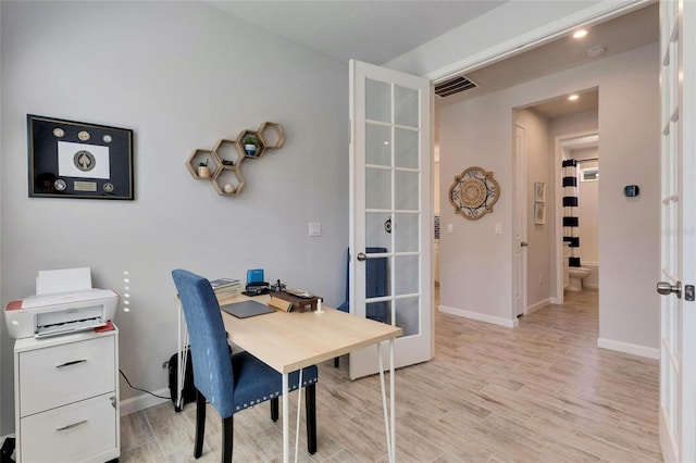 office with french doors, light wood-type flooring, visible vents, and baseboards