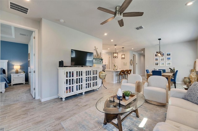 living area featuring ceiling fan, light wood-style flooring, visible vents, and recessed lighting