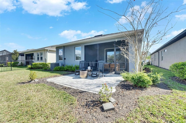 rear view of house with fence, a sunroom, a lawn, stucco siding, and a patio area