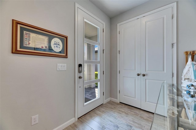 entryway featuring light wood-style flooring and baseboards