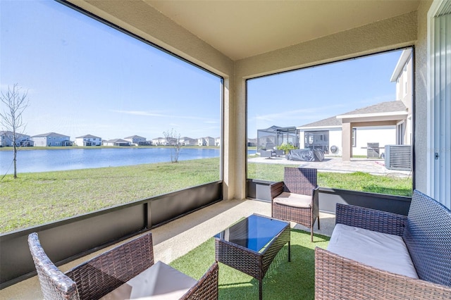 sunroom / solarium featuring a wealth of natural light, a residential view, and a water view