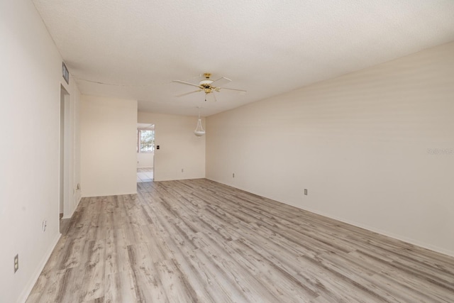 spare room featuring ceiling fan, a textured ceiling, and light wood finished floors