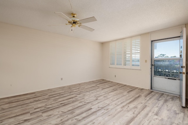 unfurnished room featuring a textured ceiling, light wood-type flooring, and a ceiling fan