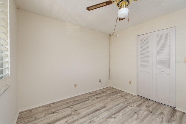 unfurnished bedroom with light wood-style floors, ceiling fan, baseboards, and a closet