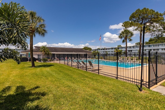 community pool with a yard and fence