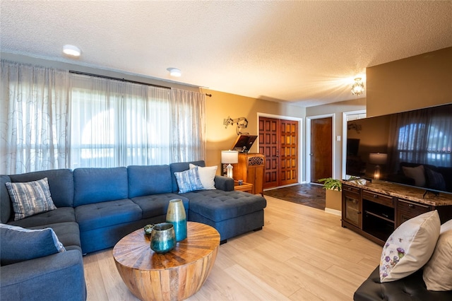 living area with light wood-type flooring and a textured ceiling