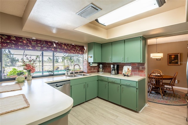 kitchen featuring green cabinets, light countertops, dishwasher, and a sink