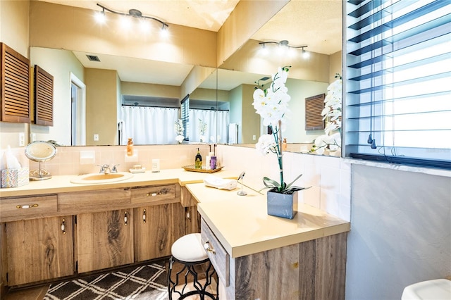 full bathroom with visible vents, backsplash, and vanity