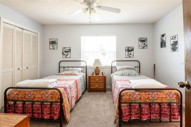 carpeted bedroom featuring a closet, a textured ceiling, and ceiling fan