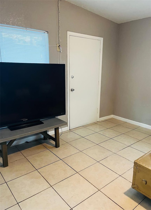 unfurnished living room featuring light tile patterned floors and baseboards