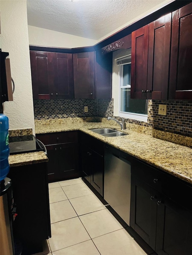 kitchen featuring light tile patterned floors, tasteful backsplash, a sink, dark brown cabinets, and dishwasher