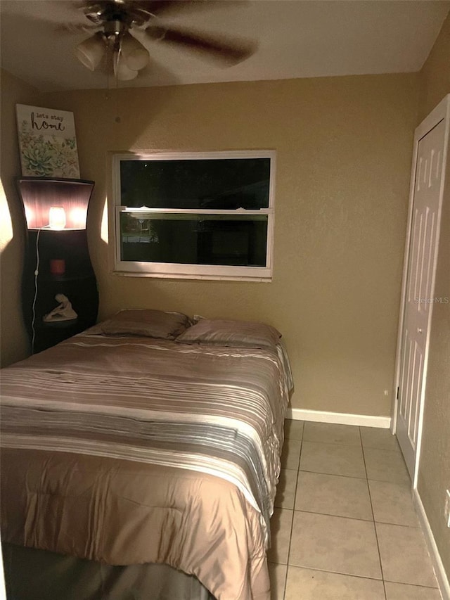 bedroom with ceiling fan, baseboards, and tile patterned floors