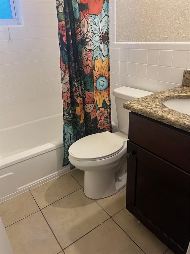 full bathroom with toilet, vanity, tile walls, tile patterned floors, and shower / bathtub combination with curtain