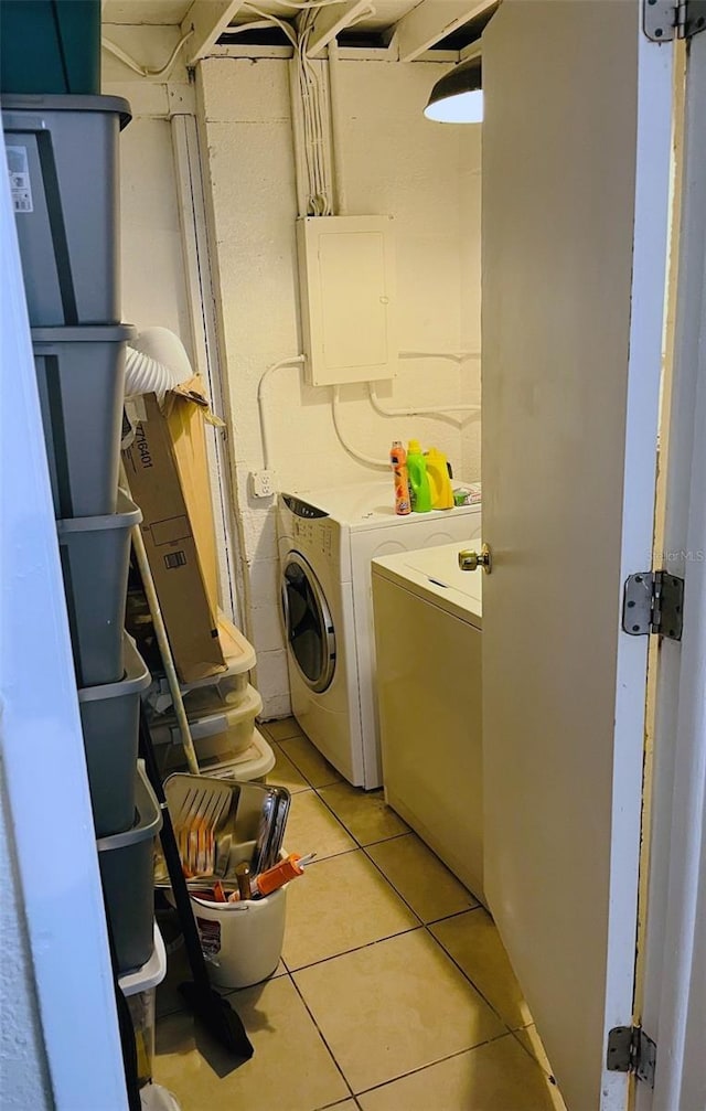 washroom with laundry area, electric panel, independent washer and dryer, and light tile patterned floors