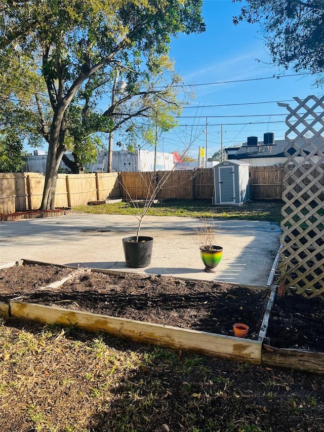 view of yard featuring a shed, a fenced backyard, and an outdoor structure