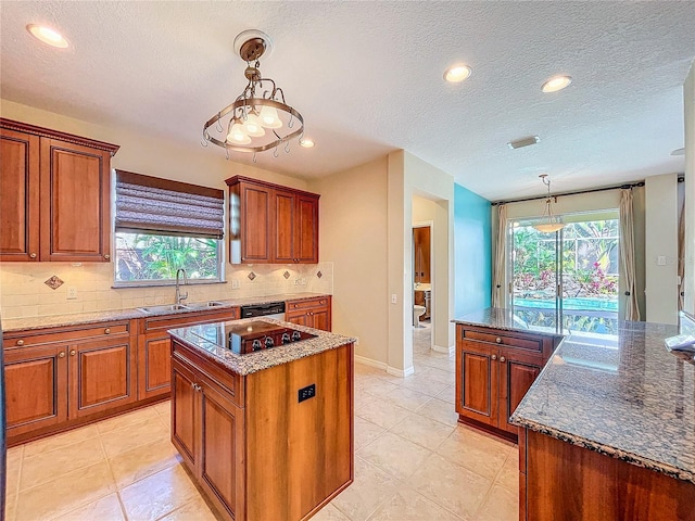 kitchen featuring a sink, backsplash, a kitchen island, and brown cabinetry