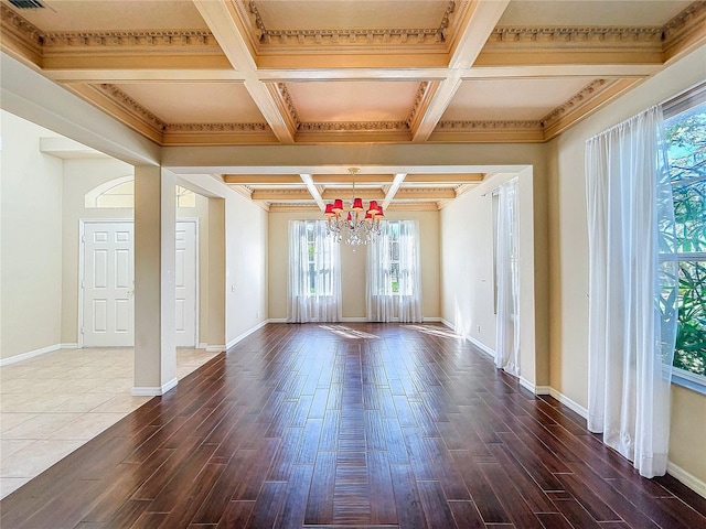 empty room with baseboards, coffered ceiling, an inviting chandelier, and wood finished floors