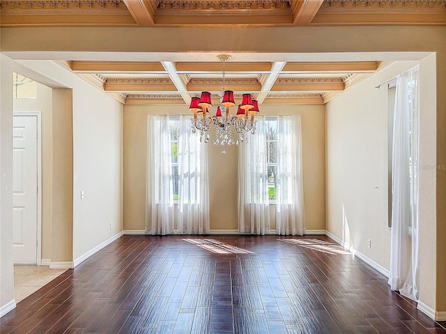 spare room featuring baseboards, a chandelier, coffered ceiling, and wood finished floors