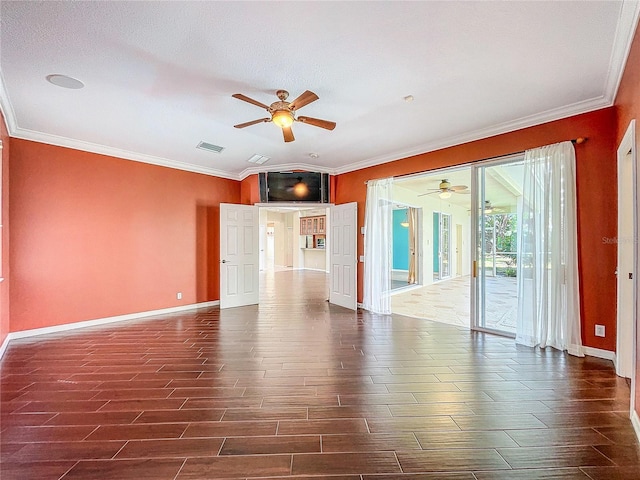 empty room featuring baseboards, visible vents, dark wood finished floors, and crown molding