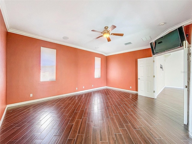 empty room featuring dark wood-style floors, visible vents, and ornamental molding