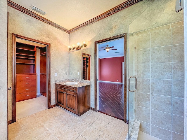 full bathroom featuring crown molding, visible vents, a stall shower, vanity, and tile patterned flooring