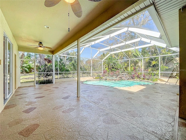 pool featuring glass enclosure, a patio area, and ceiling fan