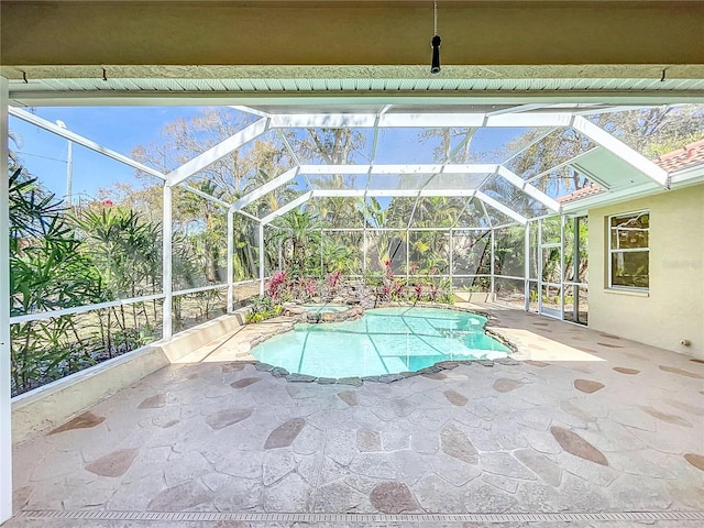 view of pool featuring glass enclosure, a patio area, and a pool with connected hot tub