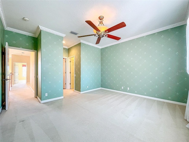 empty room with crown molding, visible vents, and wallpapered walls