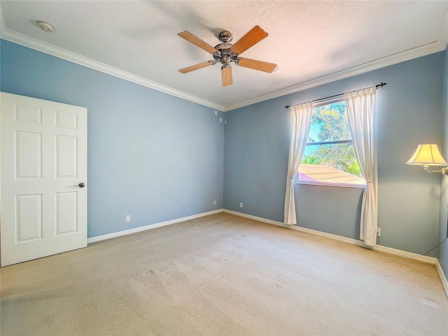 carpeted spare room with baseboards and crown molding