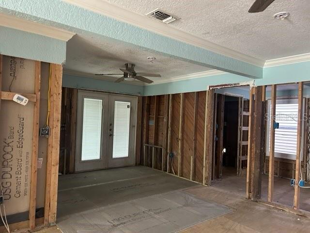 misc room featuring crown molding, visible vents, a ceiling fan, and french doors