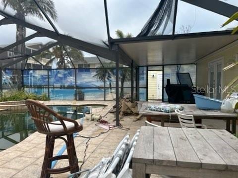 view of patio / terrace featuring glass enclosure, french doors, a jacuzzi, and an outdoor pool