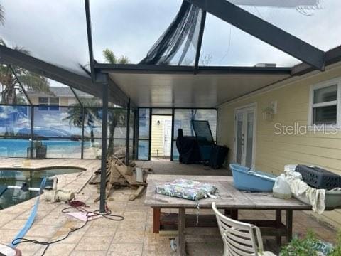 view of patio / terrace with glass enclosure, french doors, and an outdoor pool